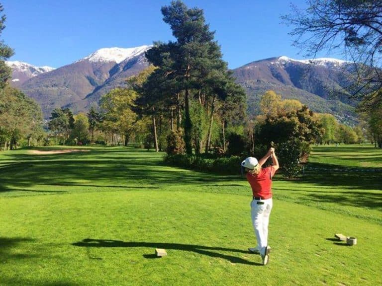 Golf Club Wylihof Golfeur swing face a la montagne